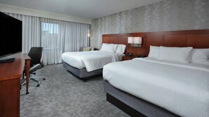 A hotel room with two beds, a desk, a TV, and a large window with curtains. - Courtyard by Marriott Beckley (Beckley)