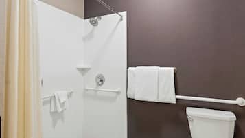 Un baño con ducha, inodoro y barra para toallas.