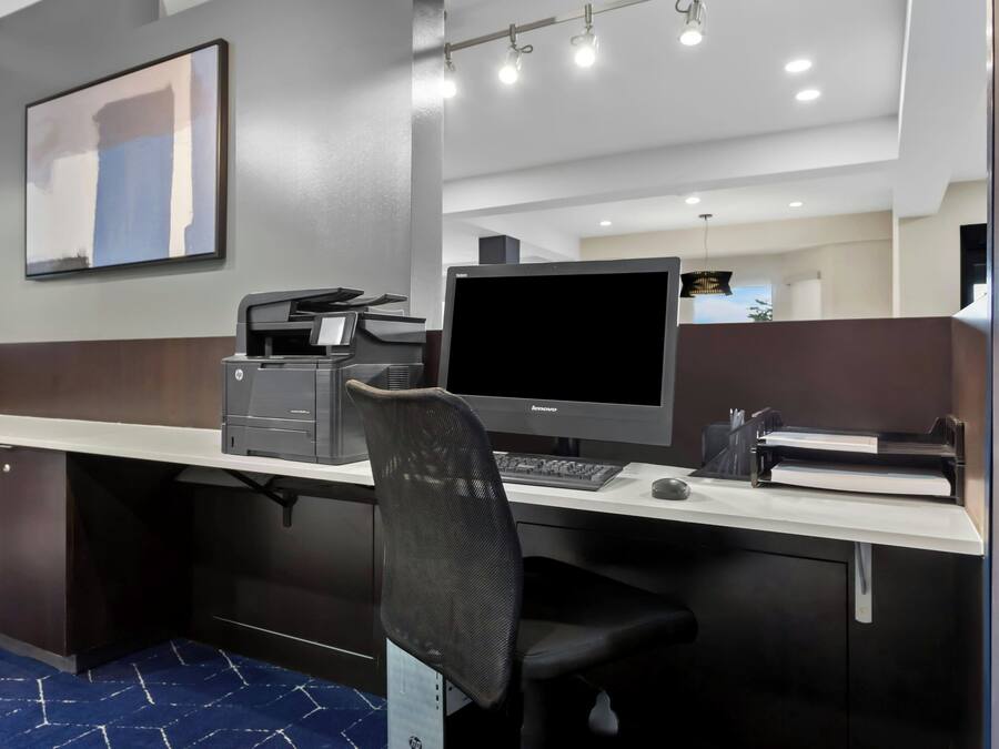 A modern office space with a desk, computer, and chair.