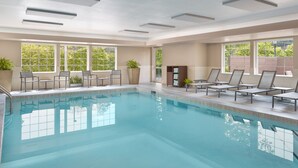 Una piscina con tumbonas y plantas en macetas.