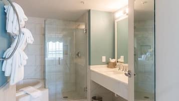 Une salle de bain moderne avec une douche à parois de verre, un lavabo blanc et un grand miroir.