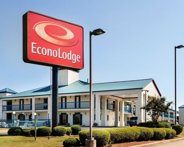 A hotel named EconoLodge with a prominent red sign, a two-story building with balconies, and a well-maintained lawn. - Econo Lodge Canton I-55 (Canton)