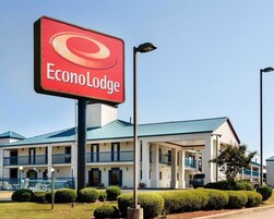 A hotel named EconoLodge with a prominent red sign, a two-story building with balconies, and a well-maintained lawn.