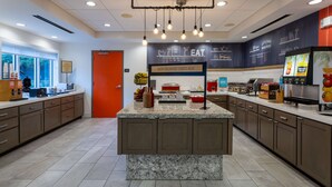 A modern kitchen with a marble island, built-in cabinets, and a breakfast bar.