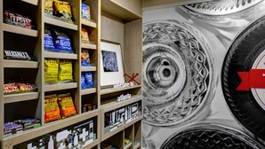 A snack display with various chips and candies, a framed welcome sign, and a large tire-themed artwork.