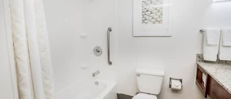 A modern bathroom with a bathtub, toilet, and shower.