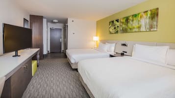 A hotel room with two beds, a TV, a desk, and a painting on the wall.