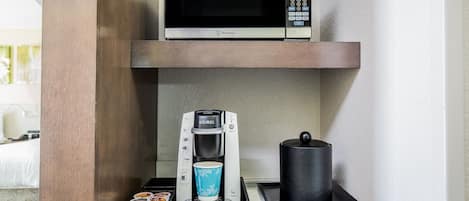 A kitchenette with a microwave, coffee maker, and a kettle.