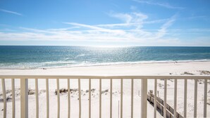 A beach with a clear sky and a railing in the foreground. - Hilton Garden Inn Orange Beach Beachfront (Orange Beach)