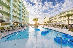 Una piscina al aire libre, sombrillas, sillones reclinables de piscina