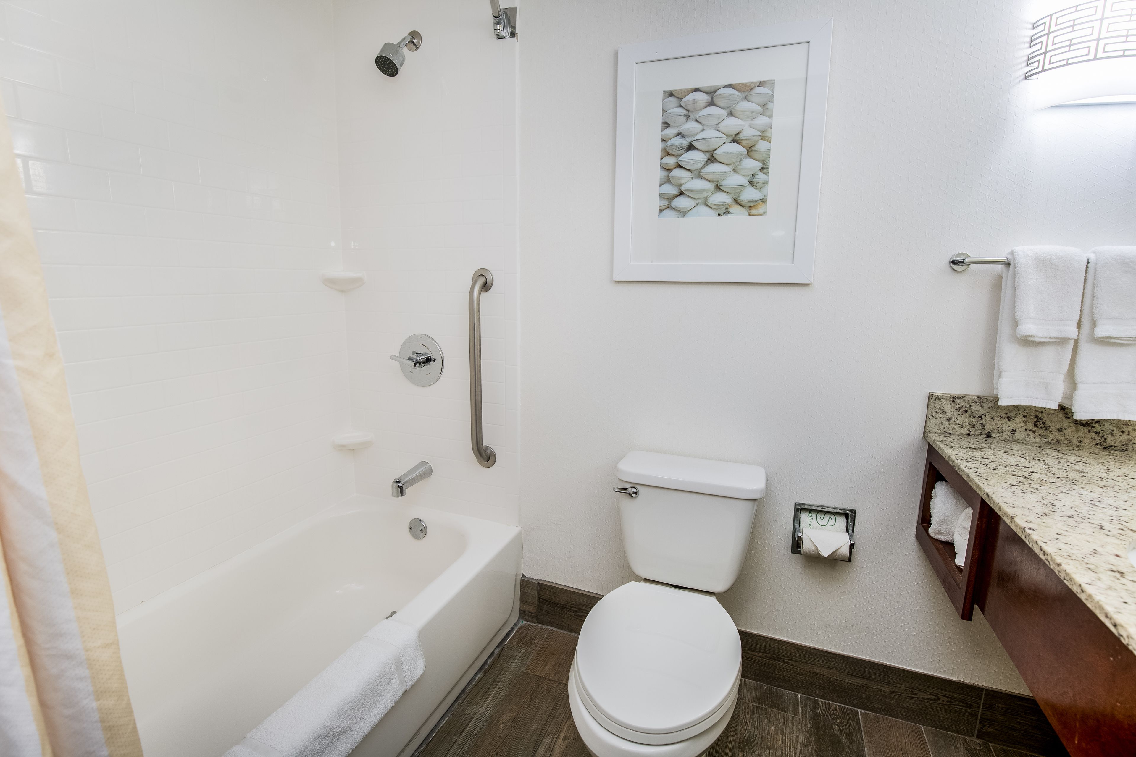A bathroom with a bathtub, toilet, and a sink with a countertop.