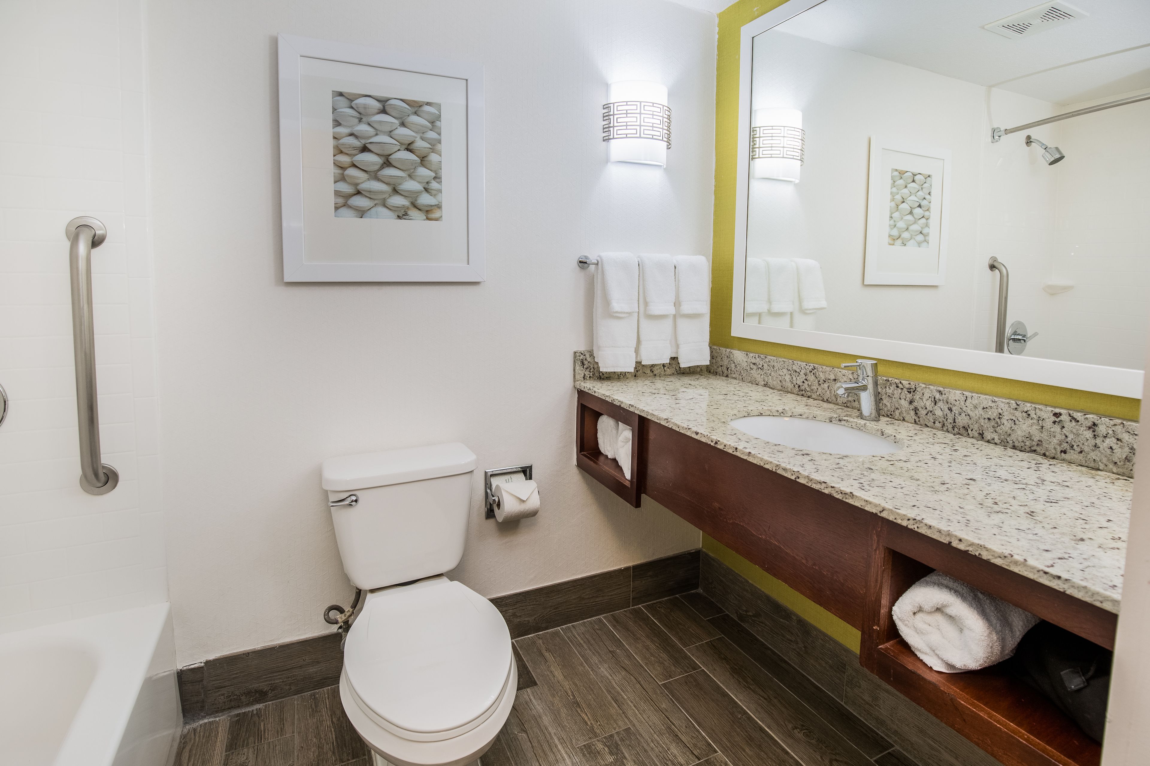 A bathroom with a toilet, sink, and mirror.