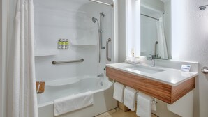 A modern bathroom with a bathtub, shower, and vanity with a mirror. - Holiday Inn Express Hope by IHG (Hope)