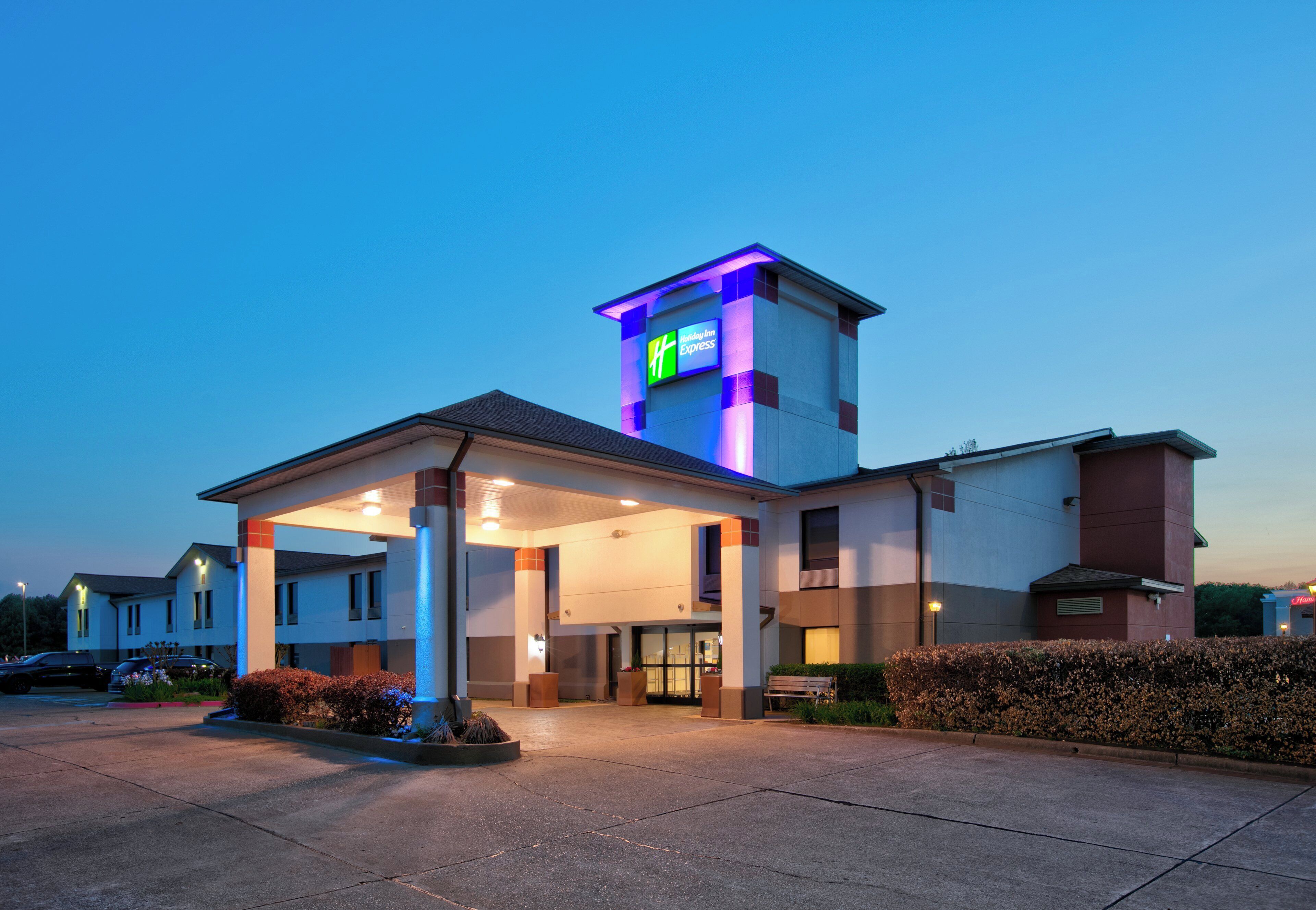 Un hôtel Holiday Inn Express doté d’une entrée abritée, d’un parking et d’une façade bien éclairée.
