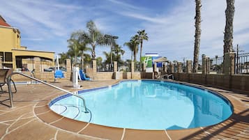 Una piscina al aire libre, sombrillas, tumbonas