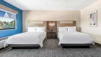 A hotel room with two beds, a large window, and a view of the outdoors.