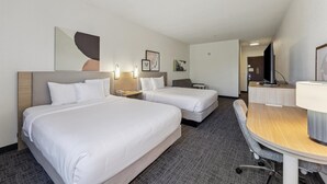 A hotel room with two beds, a desk, a chair, and a TV. - Spark by Hilton Houston near the Galleria (Houston)