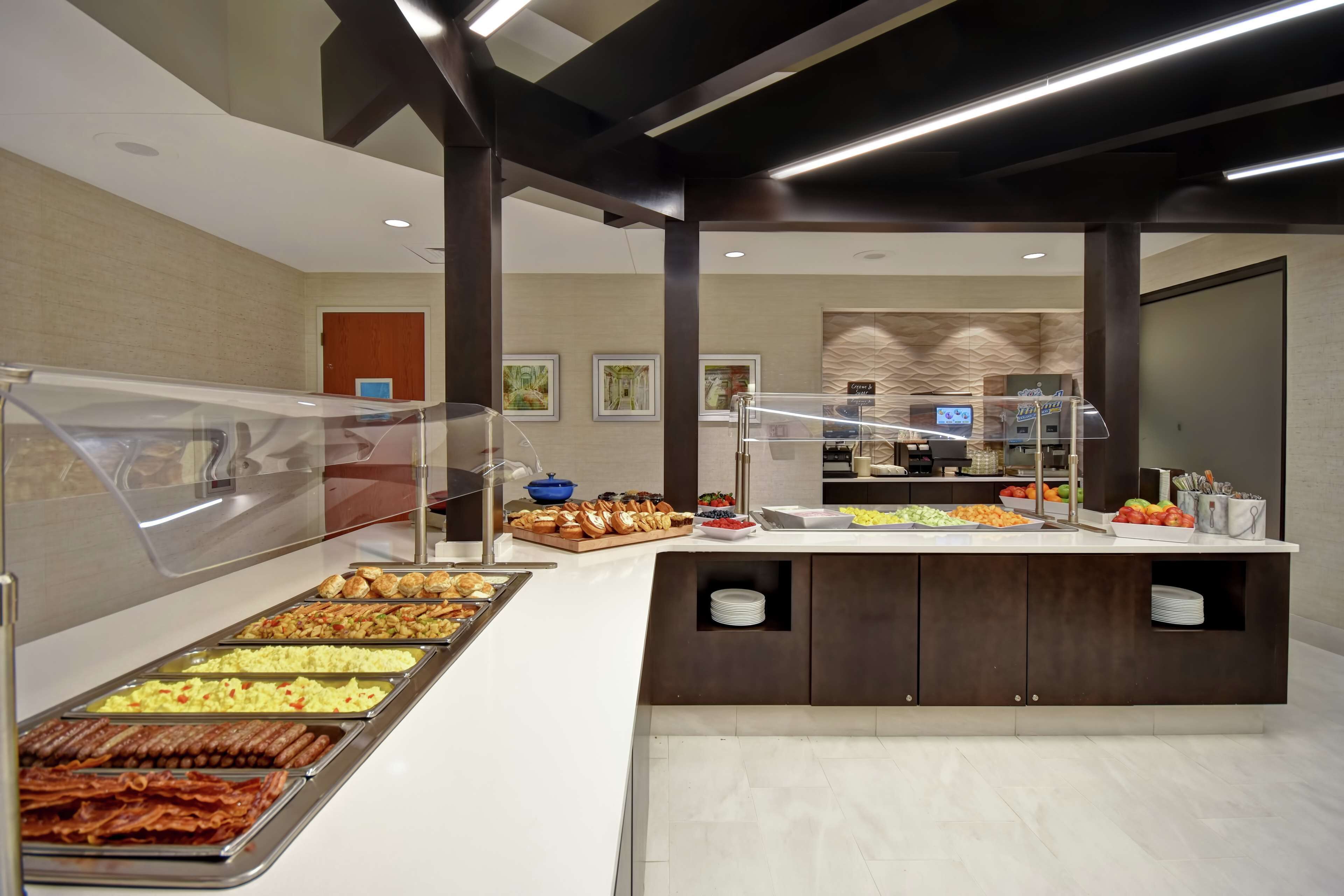 A buffet area with various food options, a coffee station, and a counter with a coffee machine.
