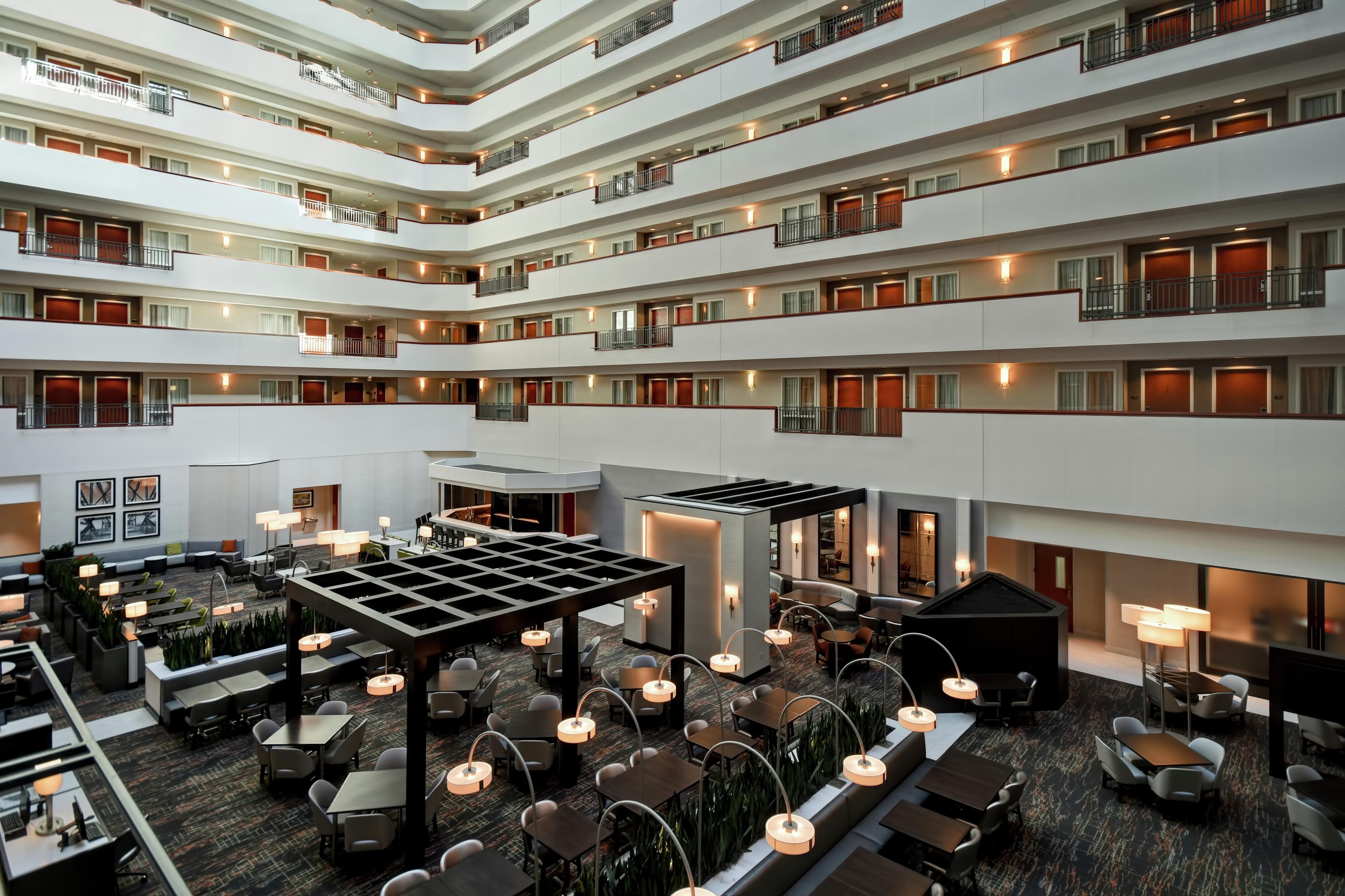 A multi-level hotel lobby with a central open space, seating areas, and a modern design.