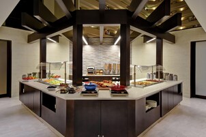 A modern breakfast buffet with a variety of food options, a central serving area, and a contemporary interior design.