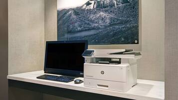 A desk with a laptop, a printer, and a mouse.