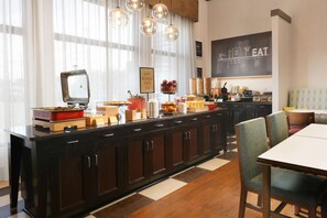 A breakfast bar with a vintage television, a chalkboard menu, and a variety of food items. - Hampton Inn & Suites Houston Medical Center NRG Park (Houston)