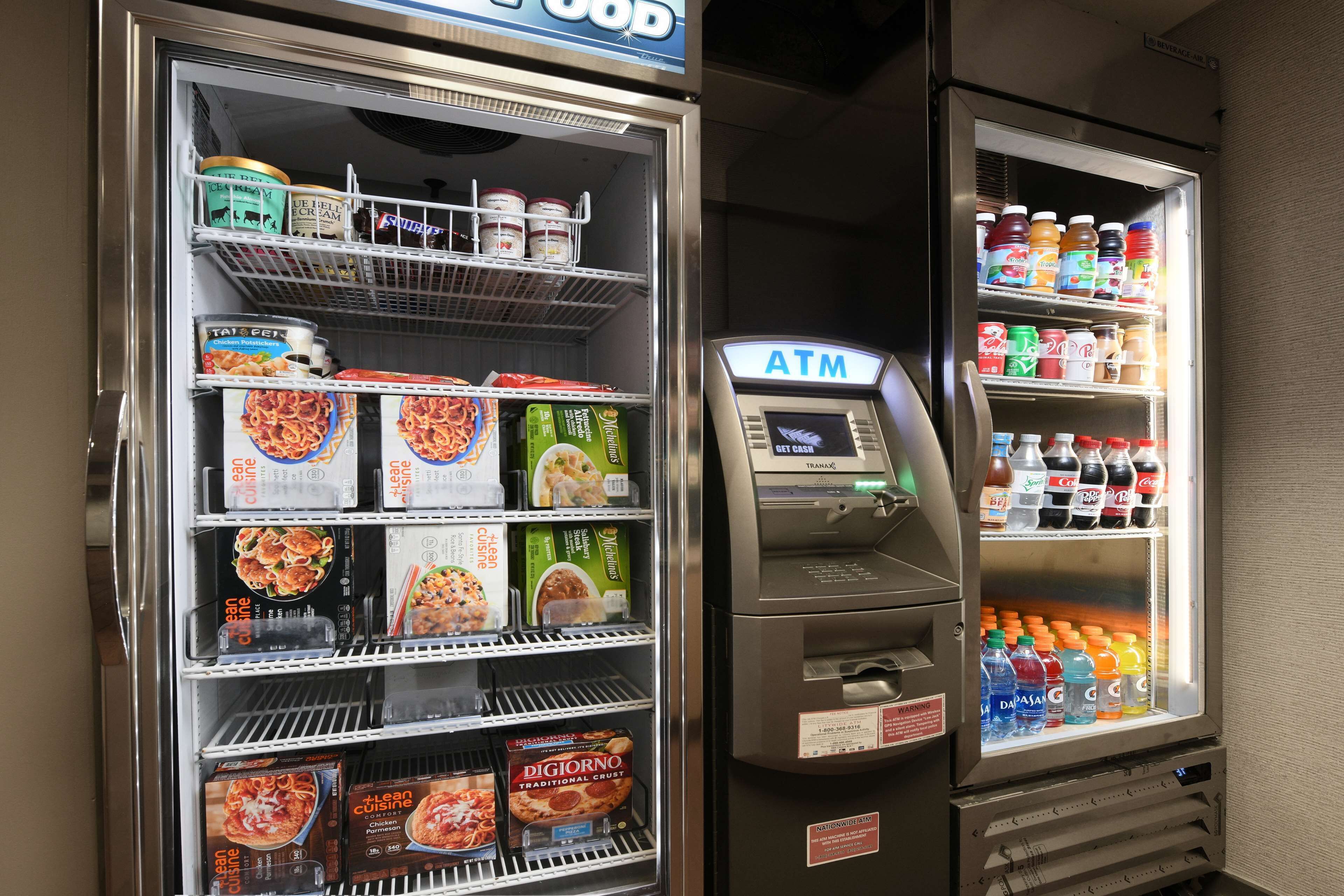A vending machine with a variety of food items and a separate ATM.