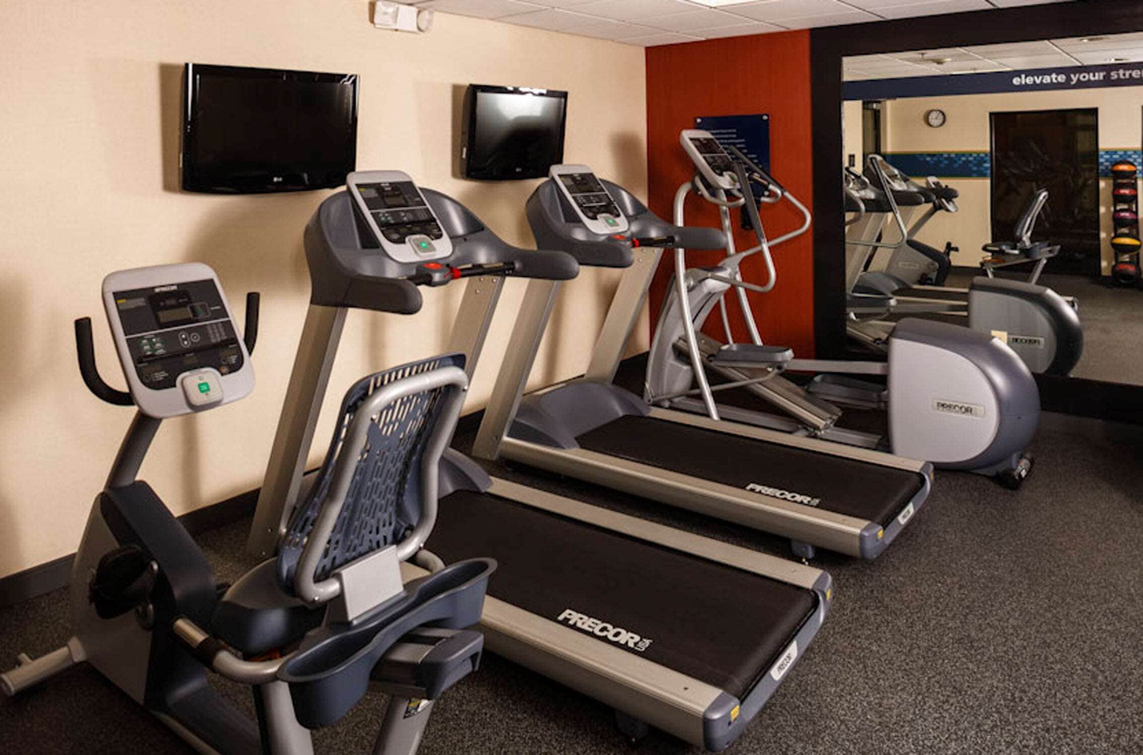 A gym with treadmills, ellipticals, and a stationary bike.