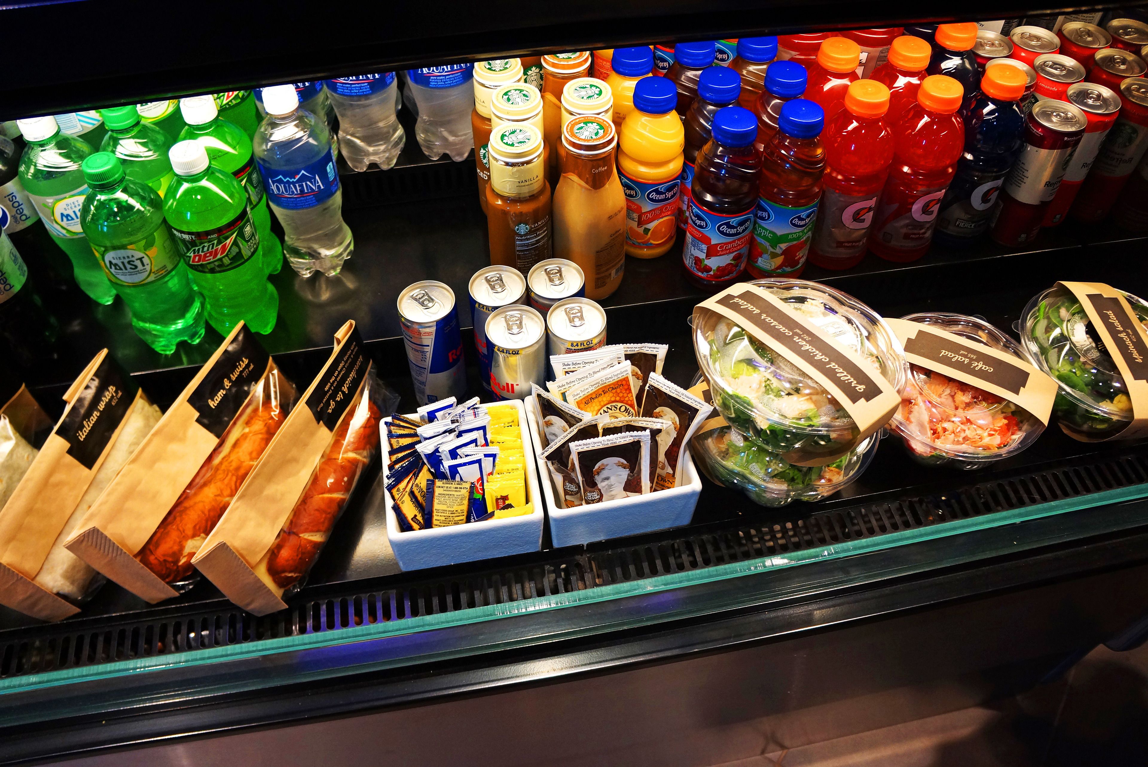 A refrigerated display case with various beverages, snacks, and packaged foods.