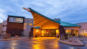 A hotel entrance with a distinctive curved roof and a sign for Hualapai Tourism. - Hualapai Lodge (Peach Springs)