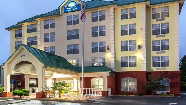 A hotel with a sign reading "Days Inn & Suites" and a flagpole with an American flag. - Days Inn & Suites by Wyndham Tucker/Northlake (Tucker)