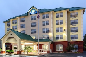 A hotel with a sign reading "Days Inn & Suites" and a flagpole with an American flag.