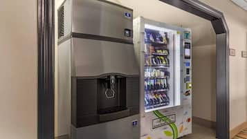A vending machine with a water dispenser and a variety of snacks and drinks.