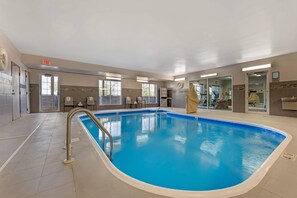 An indoor swimming pool with a clear blue water, surrounded by a tiled floor and walls, with a metal ladder leading into the pool. - Country Inn & Suites by Radisson Romeoville I-55 (Romeoville)
