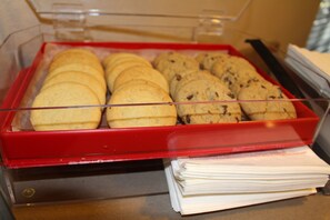 A display case with cookies and a stack of papers.