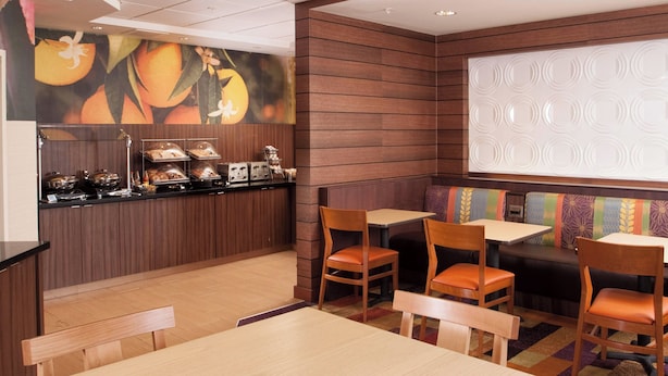 A restaurant with wooden paneling, a buffet counter, and seating areas with tables and chairs. - Fairfield Inn by Marriott Greenville-Spartanburg Airport (Greenville)