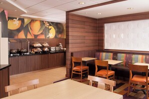 A restaurant with wooden paneling, a buffet counter, and seating areas with tables and chairs.