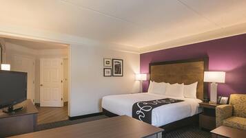 A hotel room with a bed, a desk, a television, and a chair.