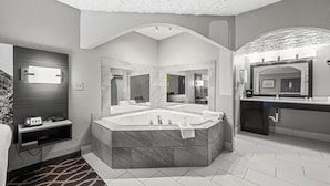 Une salle de bain moderne avec une grande baignoire sur pieds, un meuble-lavabo avec miroir et un espace douche.
