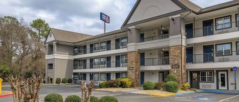 A multi-story hotel with a prominent "Hotel Lobby" sign, a parking lot with handicapped parking, and a clear sky.