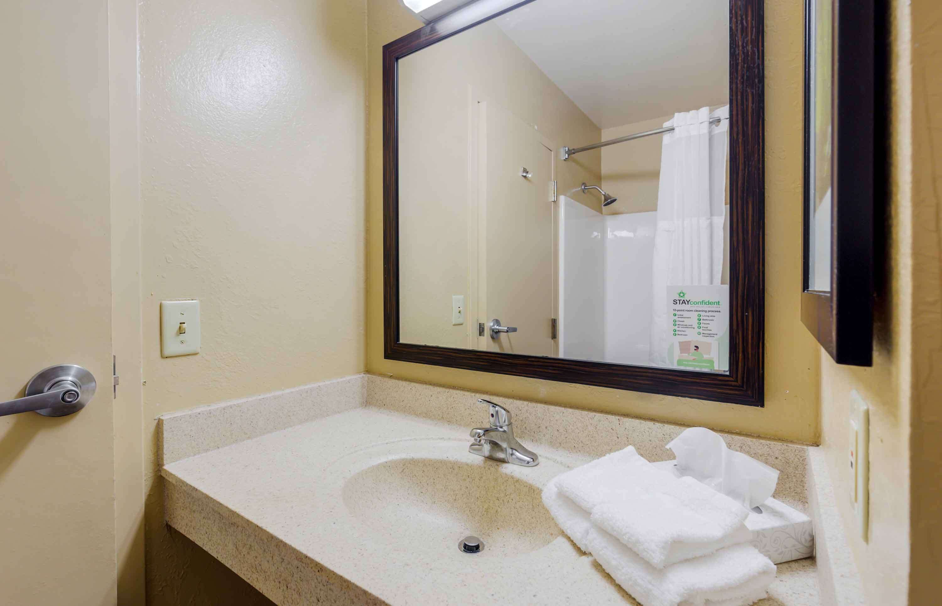 Un baño con lavabo, espejo y ducha.
