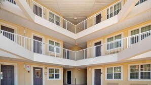 Un atrium à plusieurs niveaux, doté de balcons, de portes et d’une sortie centrale.