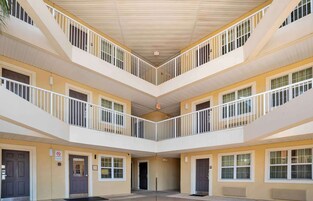 Un atrio de varios niveles con balcones, puertas y una salida central.