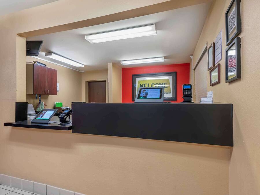 A reception area with a black counter, a digital kiosk, and framed certificates on the wall.
