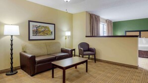 A hotel room with a sofa, armchair, coffee table, and a painting on the wall. - Extended Stay America Suites Chicago Elmhurst O'Hare (Elmhurst)