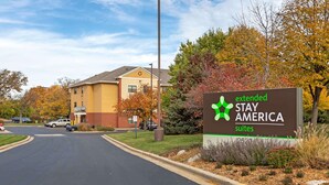 Ein Schild für Extended Stay America Suiten, mit freiem Blick auf das Gebäude im Hintergrund.
