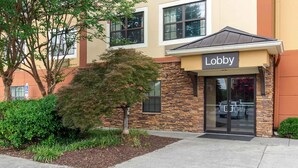 A building with a 'Lobby' sign, stone facade, and a small tree in front. - Extended Stay America Select Suites - Atlanta - Duluth (Duluth)