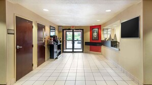 A hotel lobby with a tiled floor, a reception desk, and a door marked "TY CARE / TELEPHONE ROOM." - Extended Stay America Select Suites - Atlanta - Duluth (Duluth)