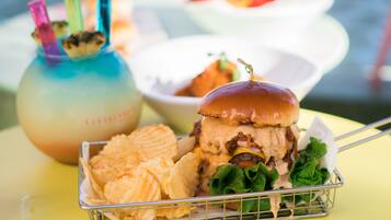 A burger with a bun, lettuce, and a side of chips in a basket.