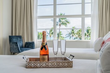 A rooftop pool area with multiple swimming pools, palm trees, and a view of the ocean. at Clevelander Hotel – Adults Only